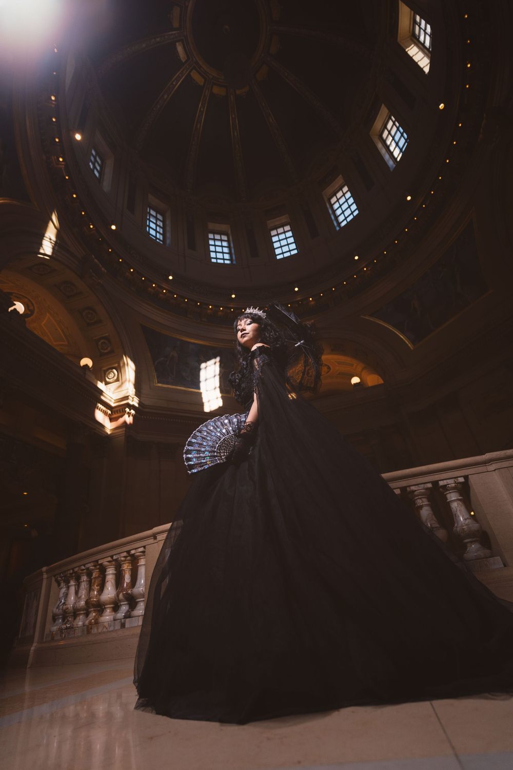 Low-angle dramatic shot in a domed ballroom with natural light streaming through windows.