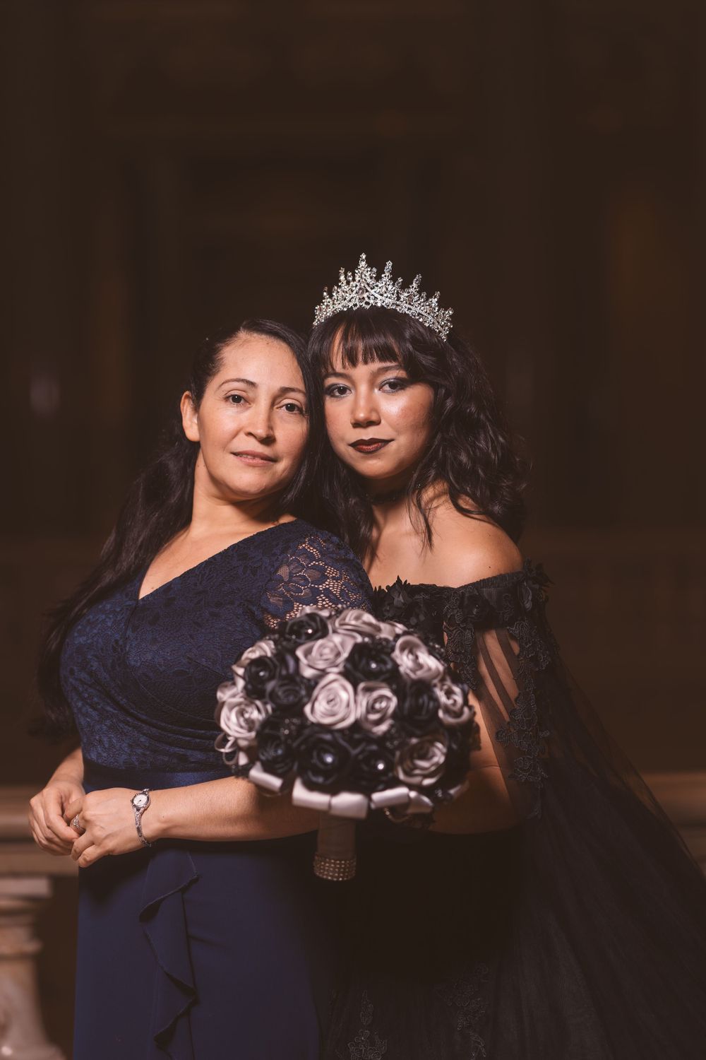 Elegant portrait session featuring formal wear and a tiara in warm lighting.