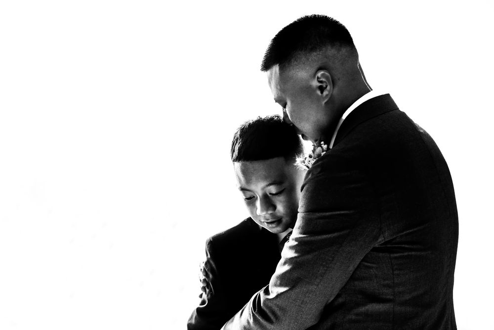 father and son embrace during the wedding day