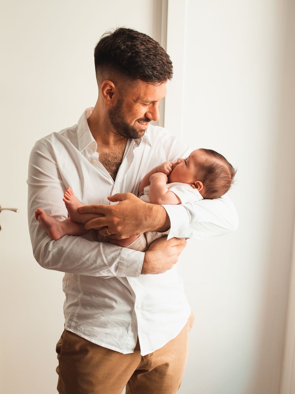 Tender family moments captured in a bright, modern living space with natural lighting.
