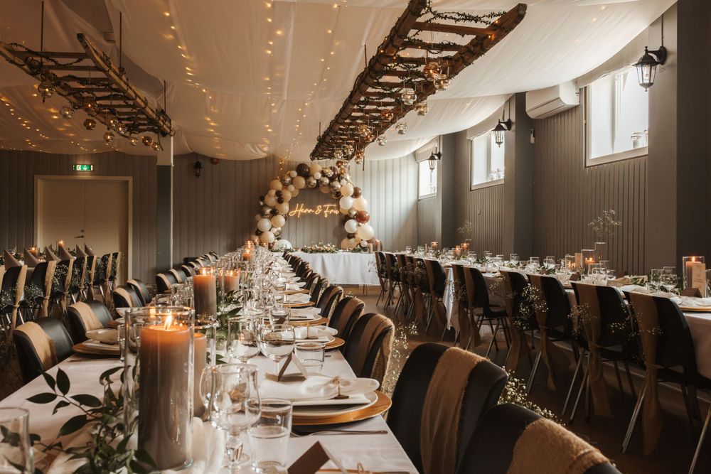 Elegant wedding reception table setting with string lights and modern industrial decor.
