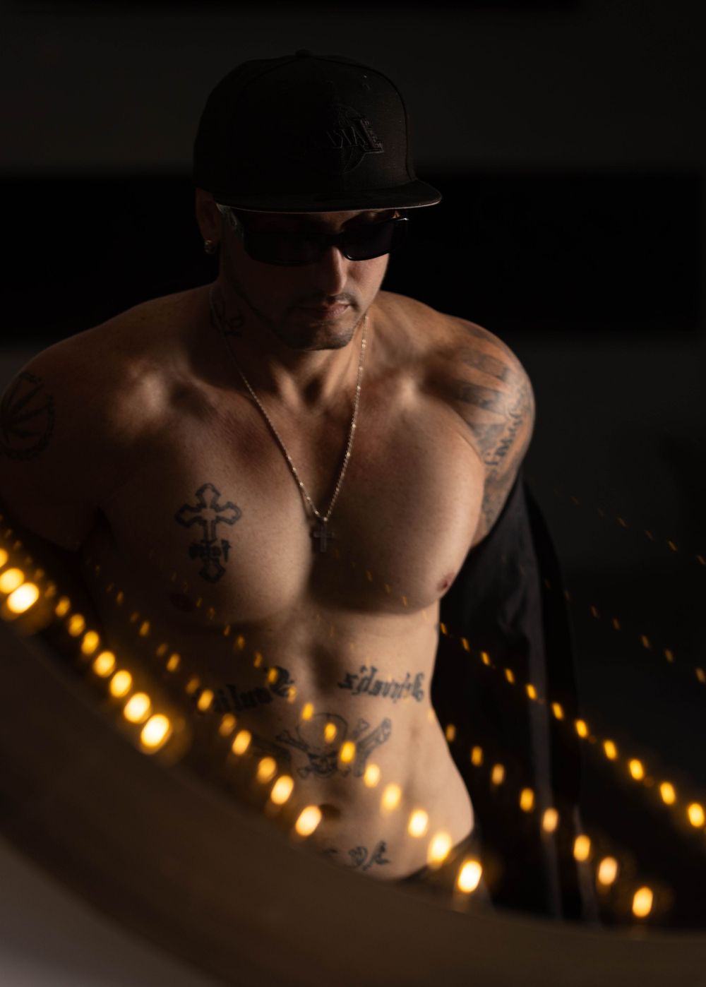 Reflection of man undressing and showing his tattoos during boudoir photo shoot.