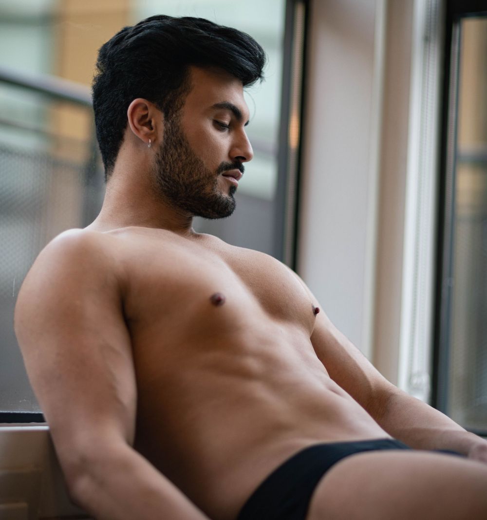Man relaxing in living room during boudoir photo shoot.