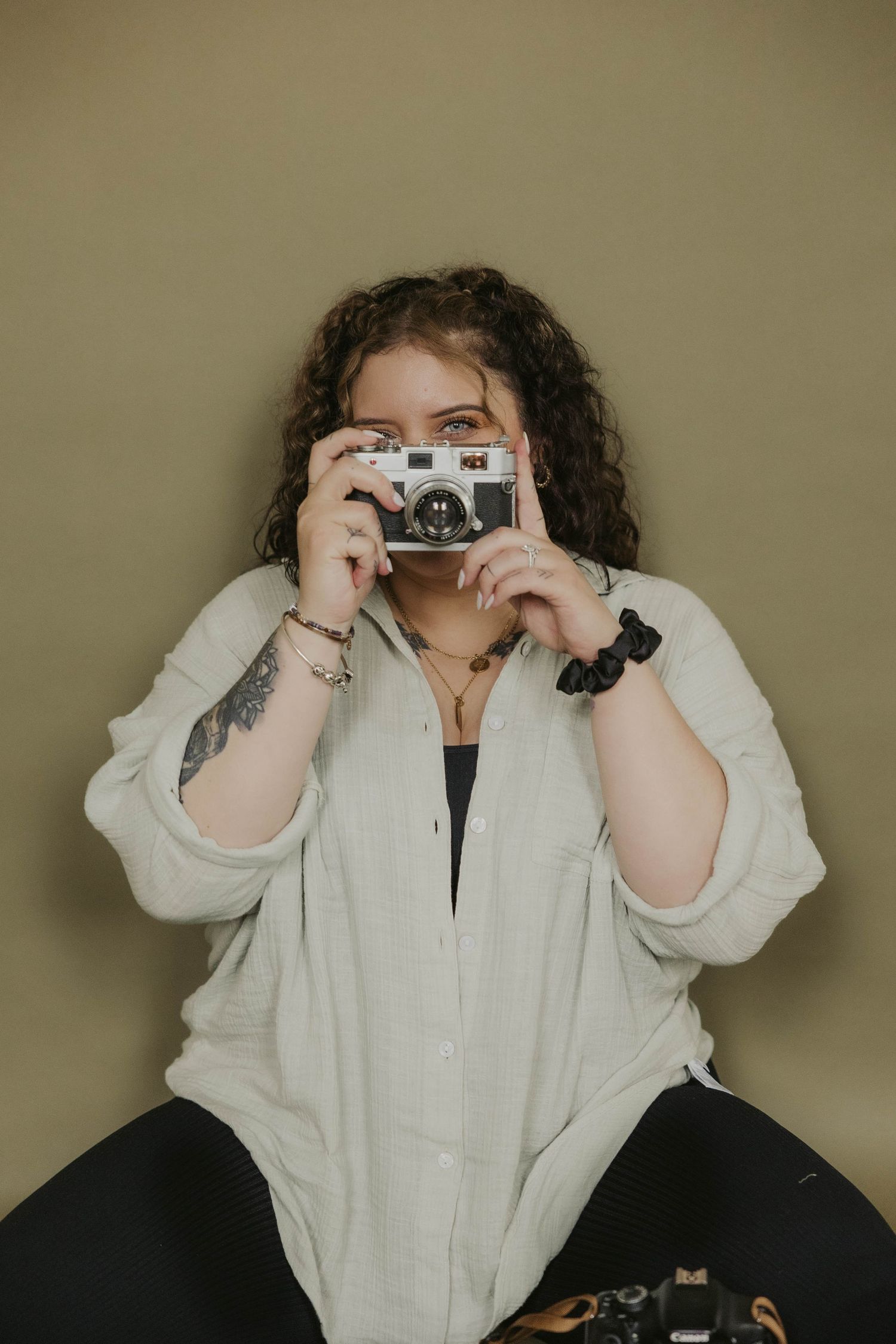 Photographer demonstrates various poses with vintage camera equipment.