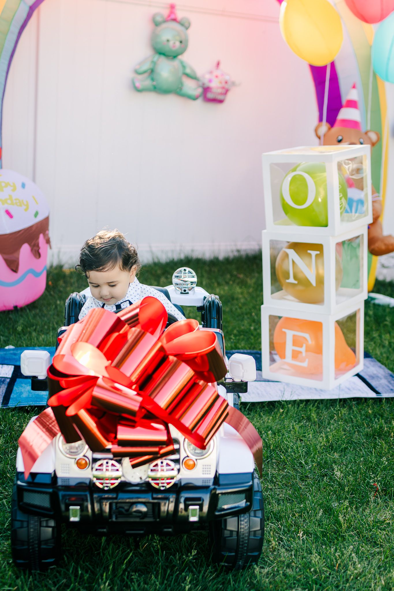 One year baby in a toy car at his birthday party