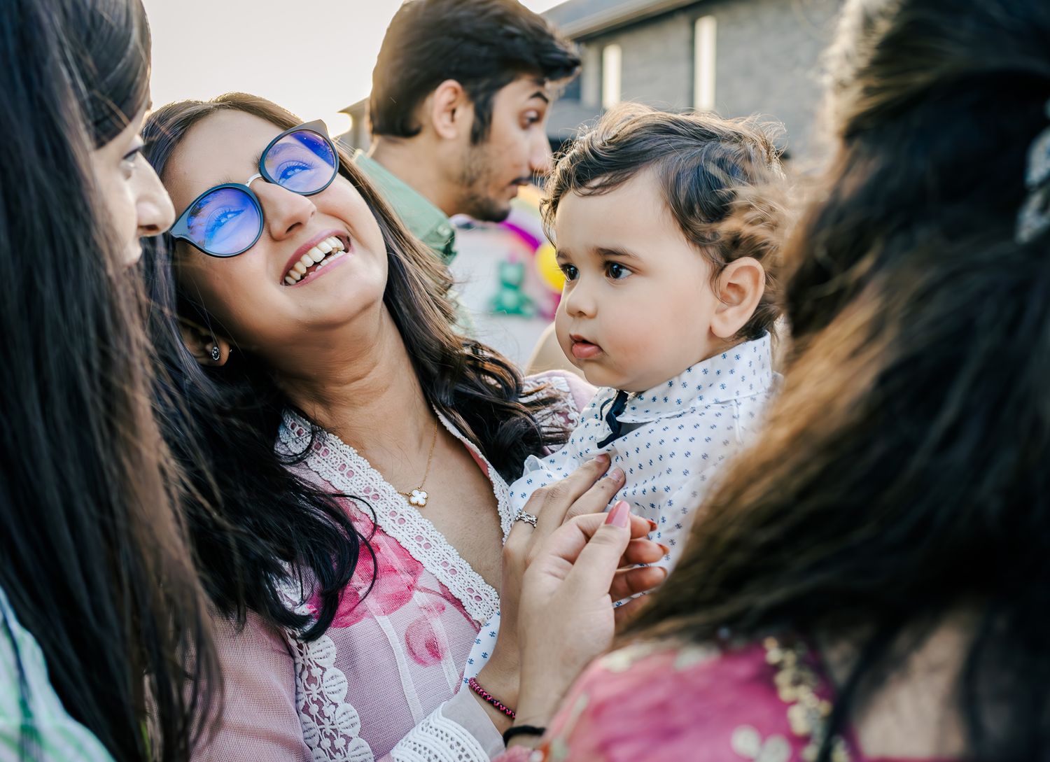Woman holding baby boy surrounded by family members