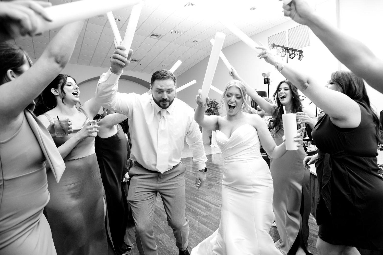 Black and white photos of wedding guests dancing and celebrating at reception.