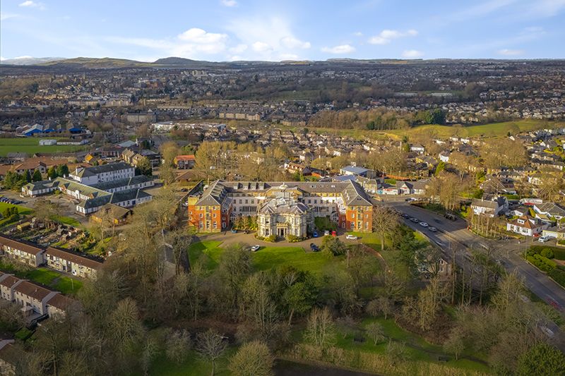 Aerial panoramic view of suburban residential neighborhoods and autumn trees in a valley during fall season.