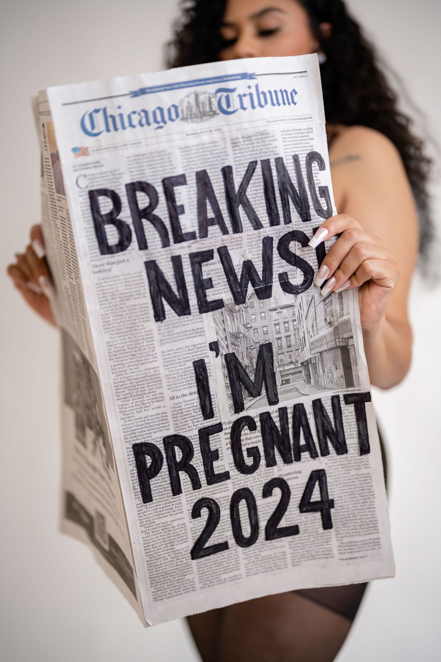 Pregnancy announcement series using Chicago Tribune newspaper with handwritten text.