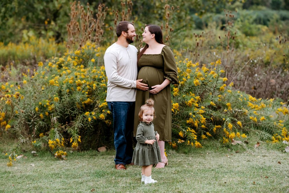 A couple embraces in a field of vibrant yellow wildflowers during a romantic outdoor photo session.