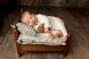 Newborn baby boy on small bed and green sheets with Tiffany Bergamino Photography in Marion indiana