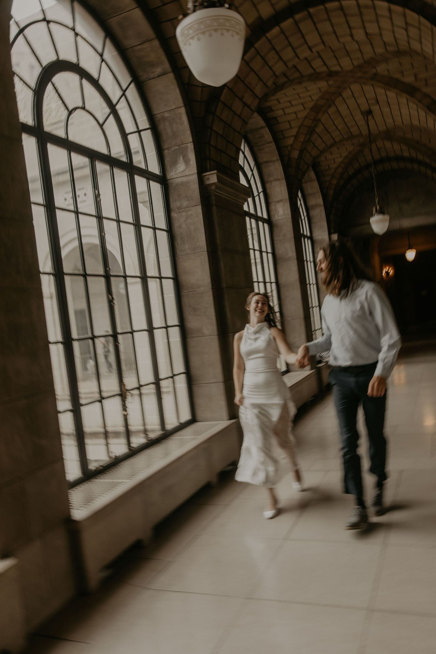 Two people dancing in front of the Omaha Union Station entrance on an overcast day.