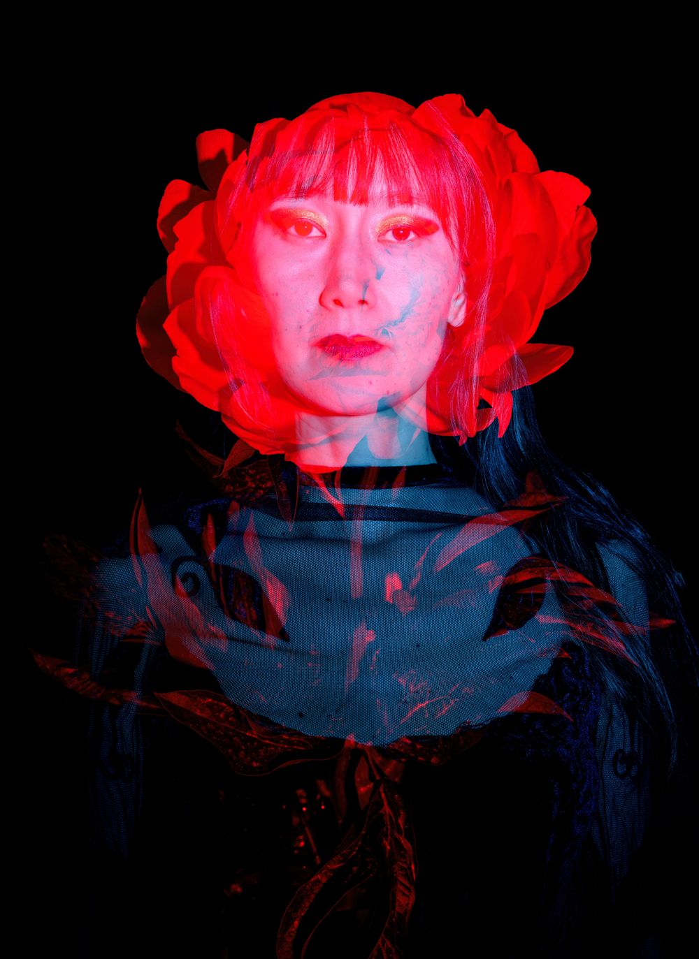 Double exposure portrait with red flower overlay creating ethereal effect.