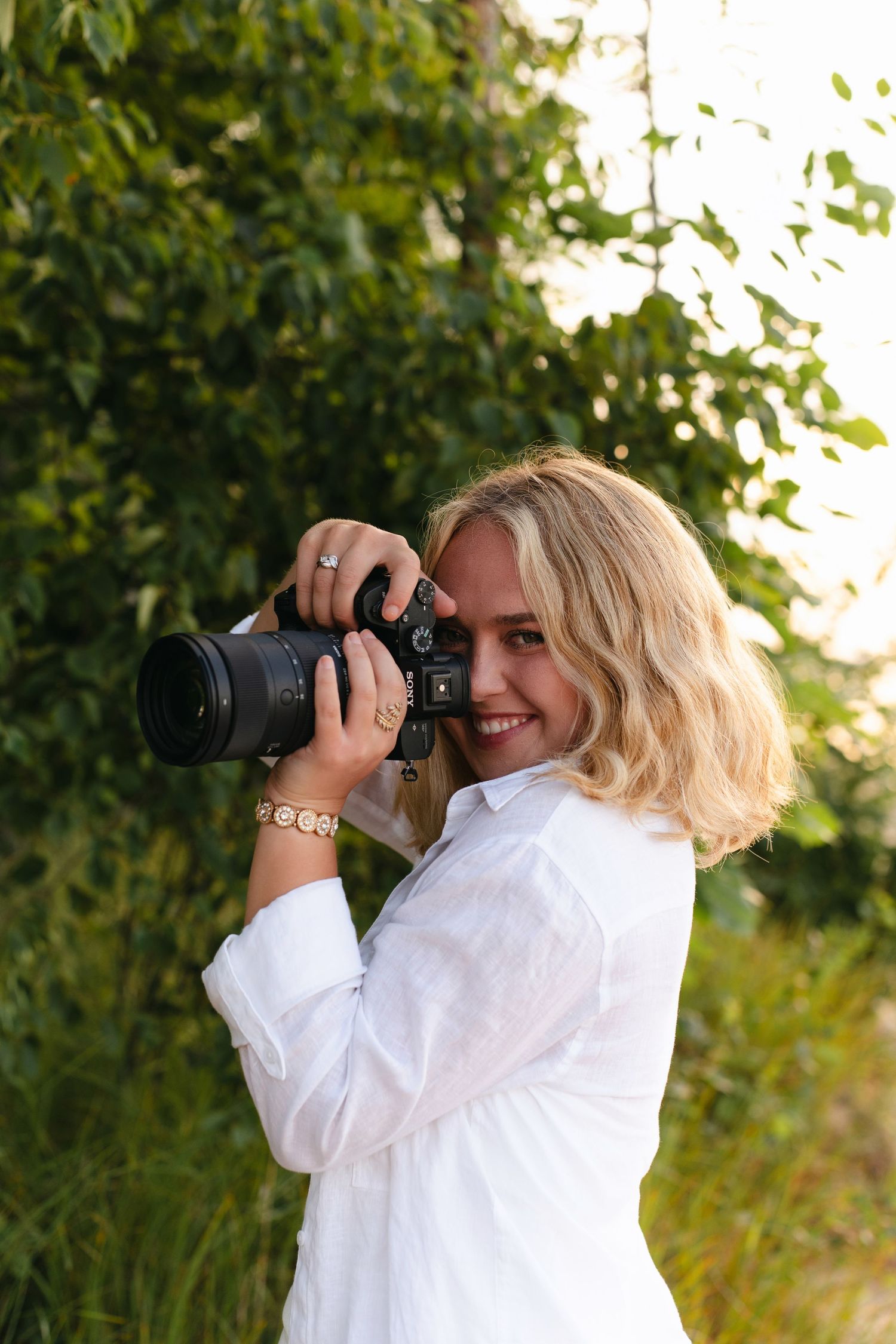 Close-up shot of hands holding a DSLR camera with natural lighting.