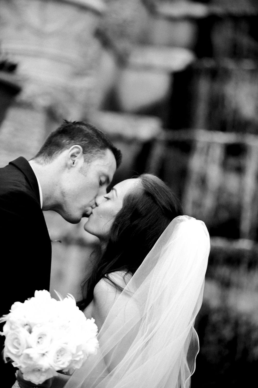 A romantic black and white wedding photo collage showing tender moments between newlyweds with white bouquet and veil.