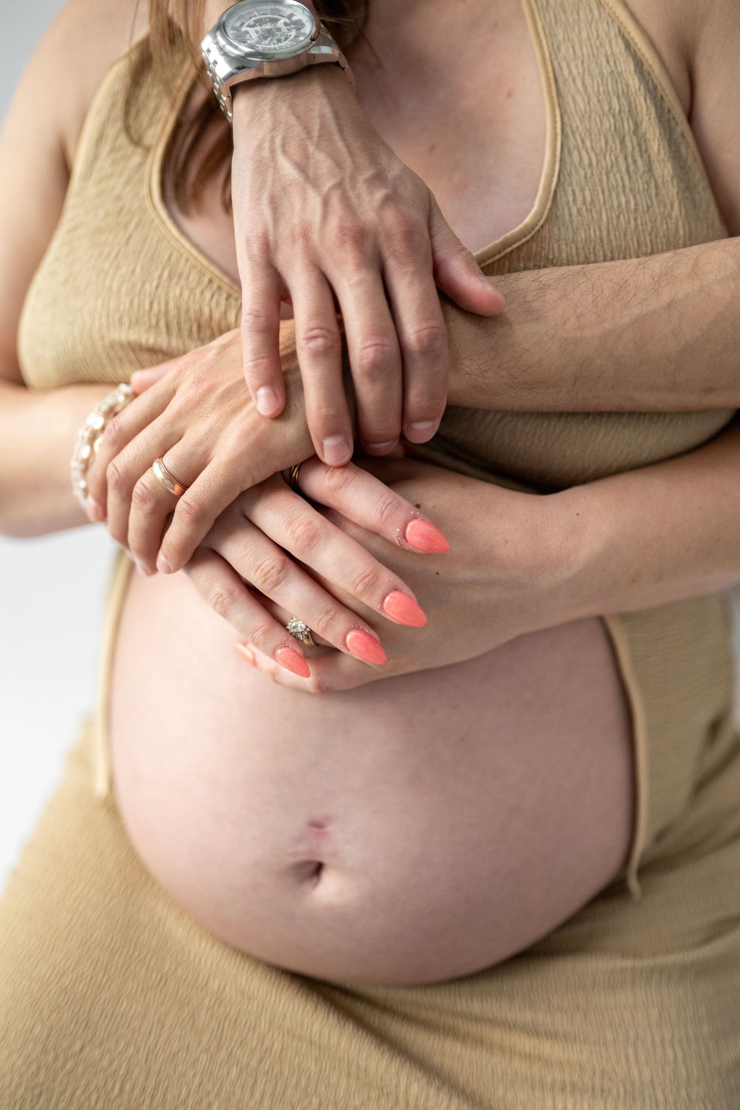 Series of close-up shots showing hands tenderly placed on pregnant belly.