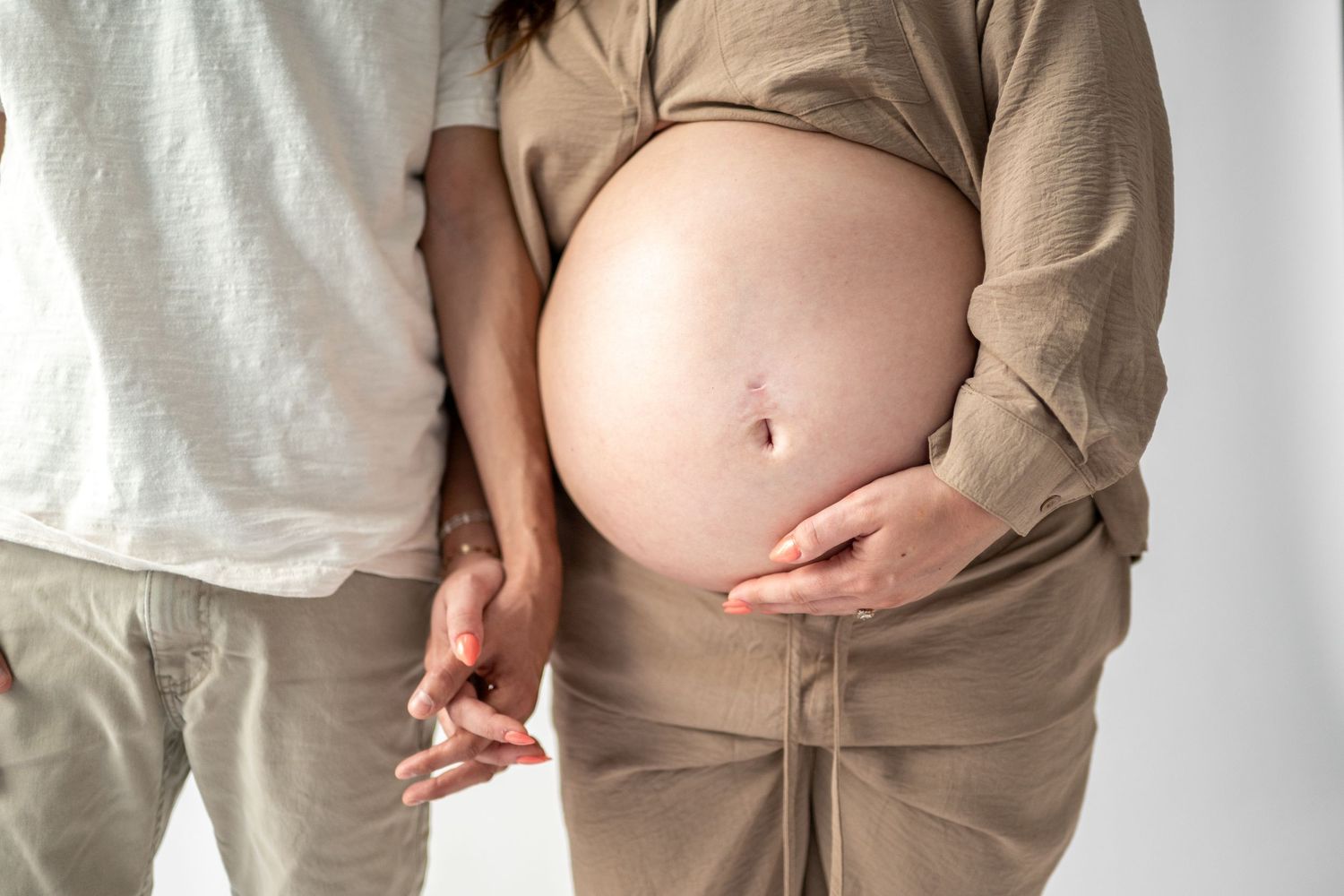 Casual maternity photos in beige outfit showing different belly angles.