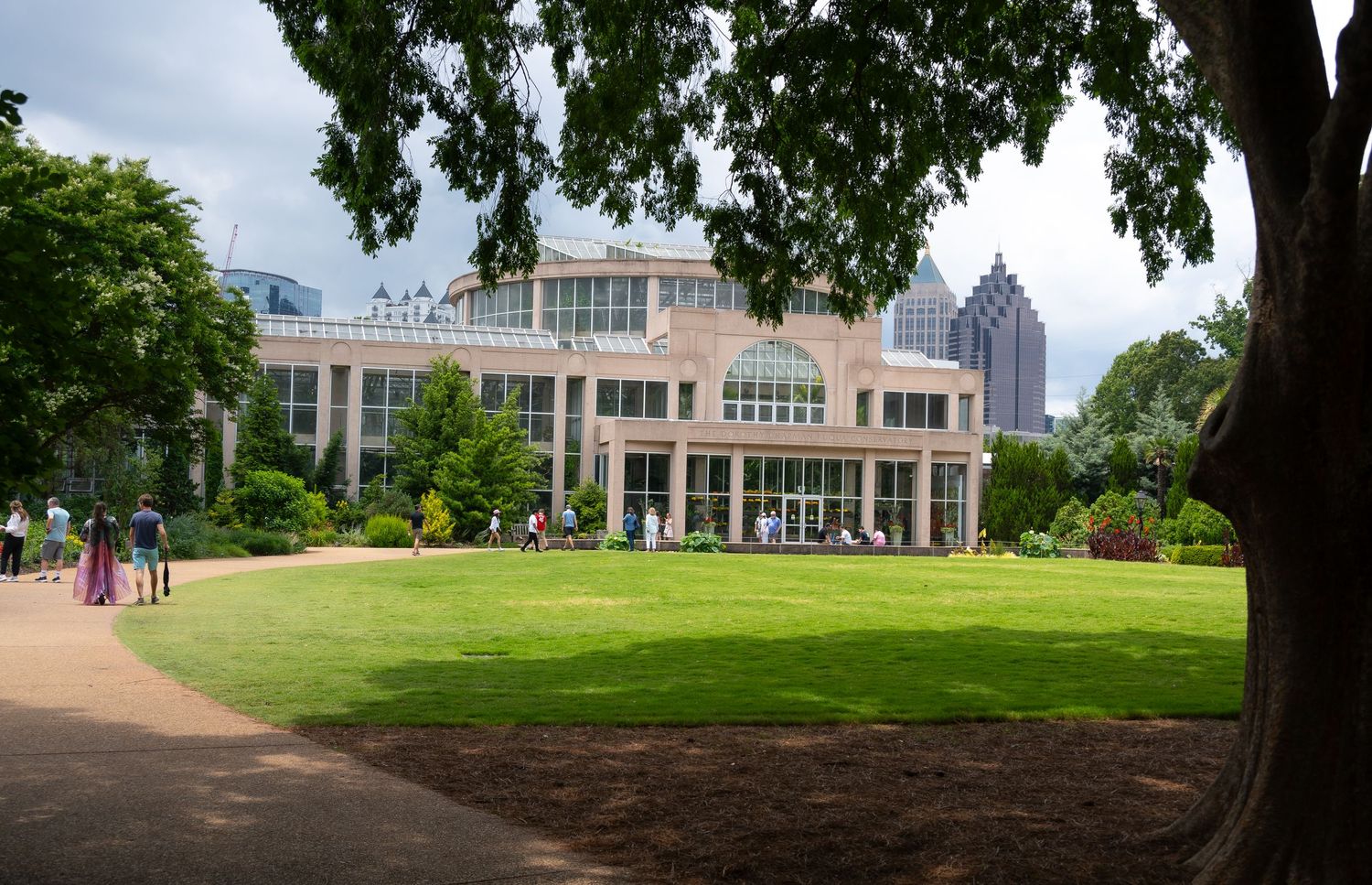 Modern building with glass windows surrounded by manicured lawn and trees on a college campus.