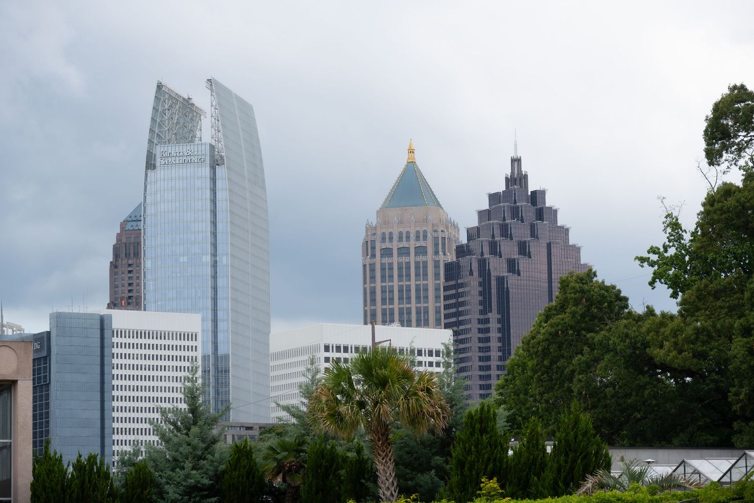 Modern skyscrapers of downtown Atlanta including iconic buildings against a cloudy sky.