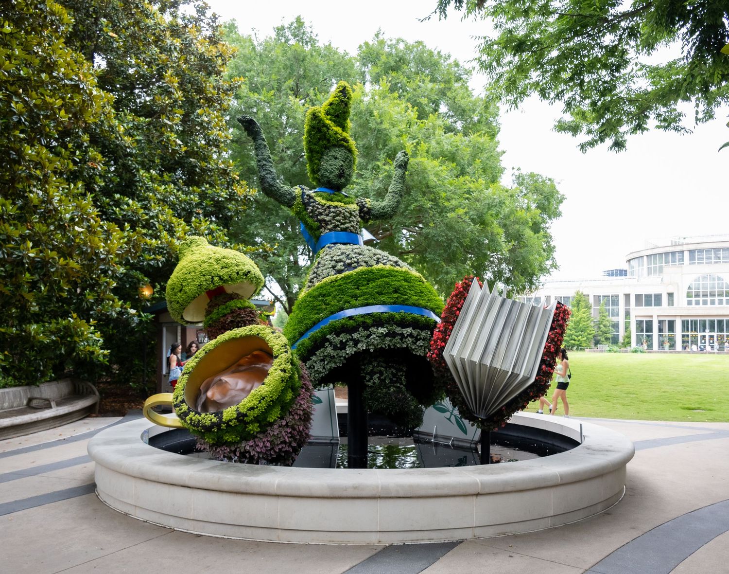 Whimsical garden sculpture featuring oversized teacups and teapots with plants growing from them.