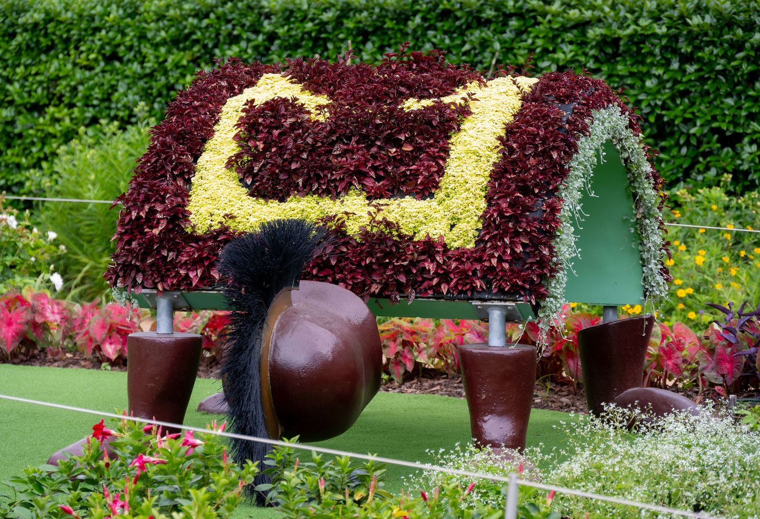Decorative garden cart with burgundy and cream colored flowers forming a patterned roof.