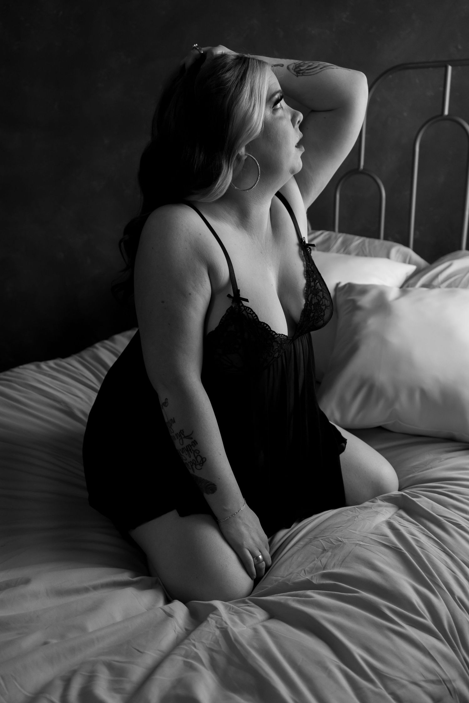 Image of woman on a bed. Posing for a Bodoir shoot. Taken in Sugarhouse, Utah.