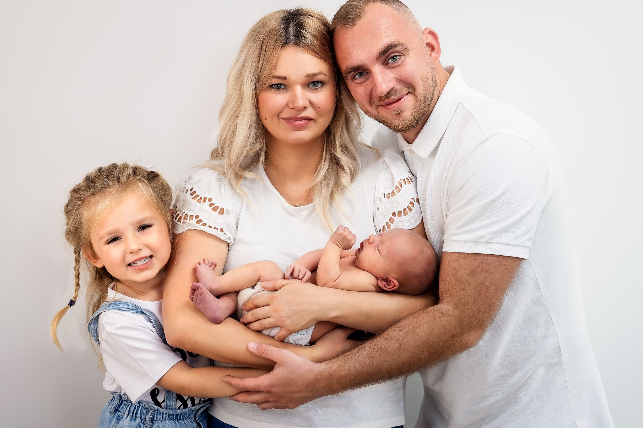 A series of family photos showing tender moments with a newborn baby and siblings against a white background.
