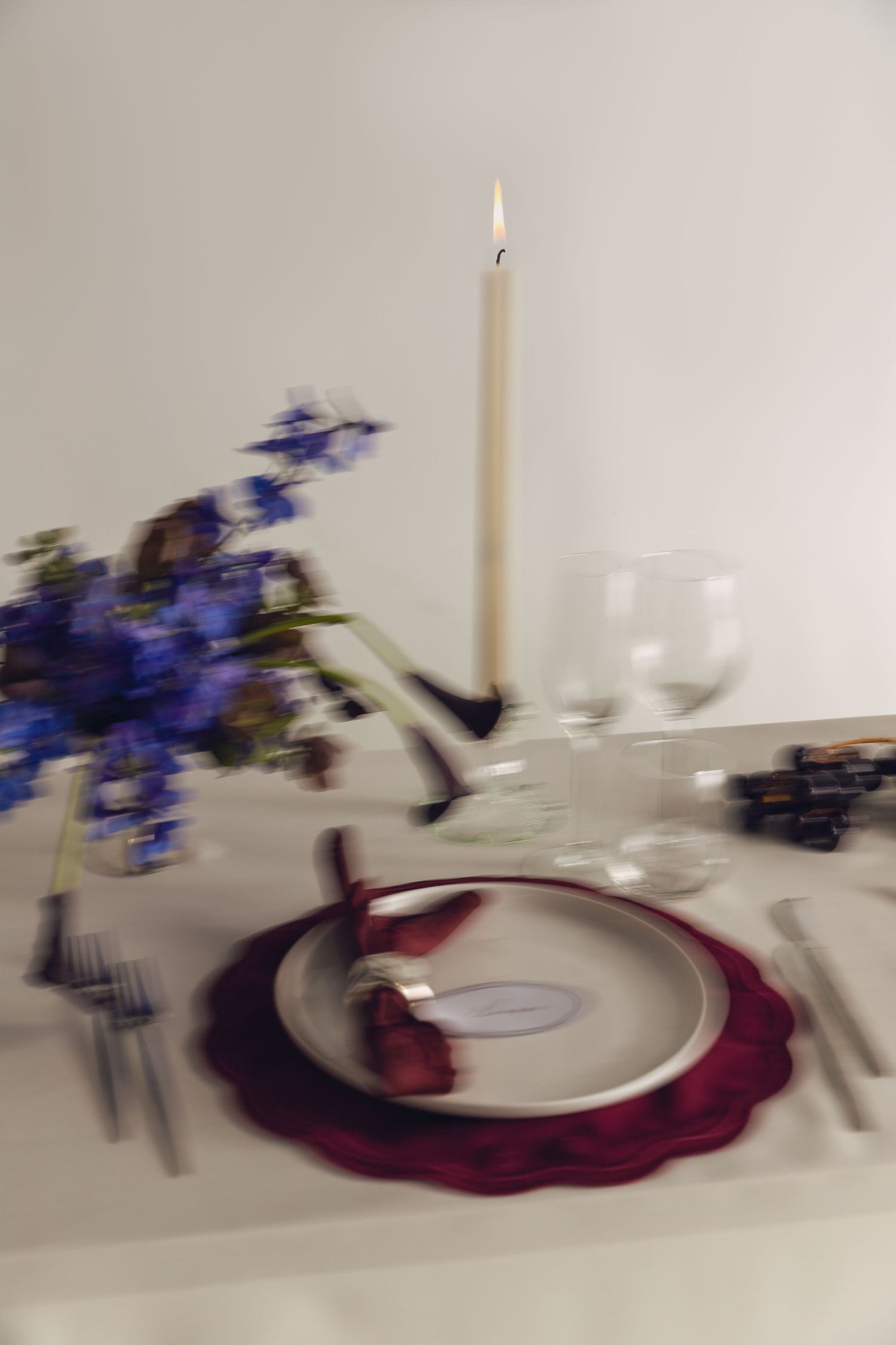 A sequence of motion blur photos showing a blue flower arrangement spinning on a white table setting with red accents.