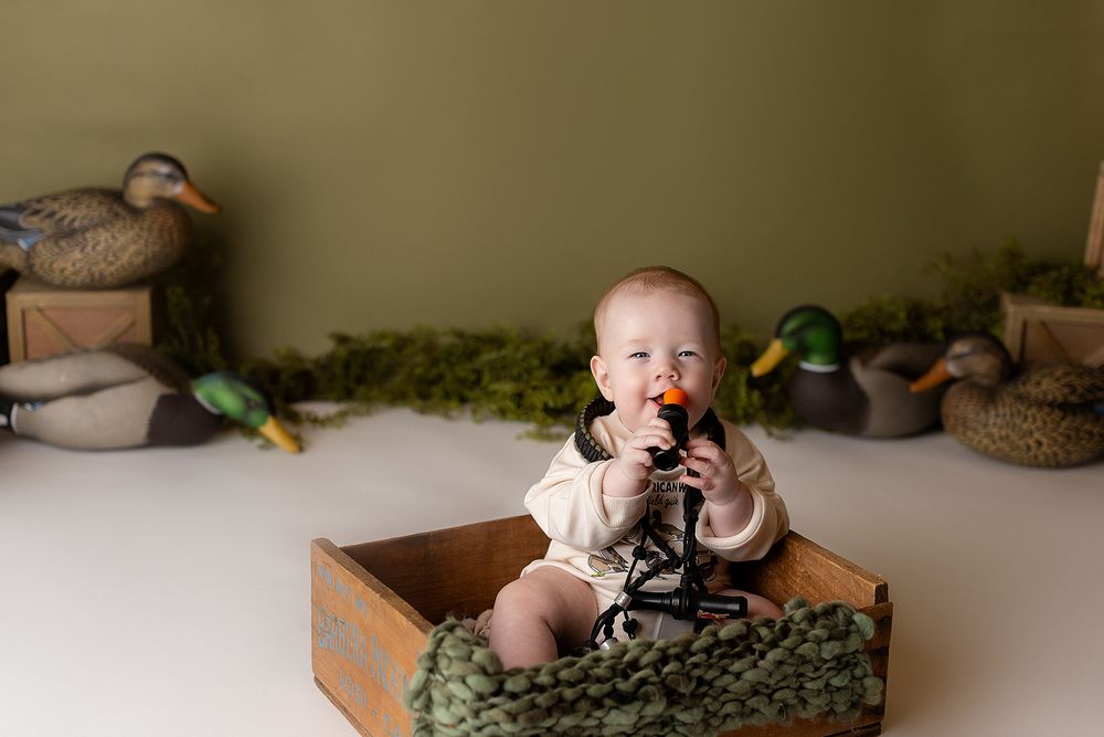 duck calls and duck decoys around a 6 month old boy for his 1/2 year photoshoot