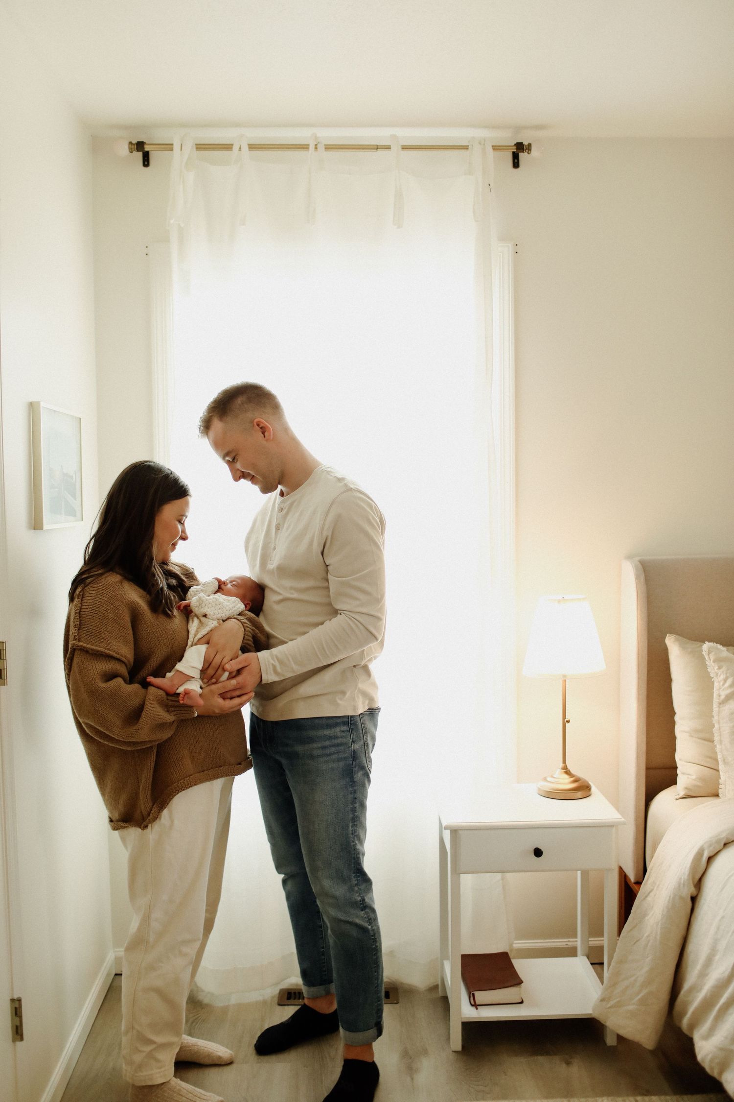 A series of four tender moments between two people interacting in a bright, minimalist white room.