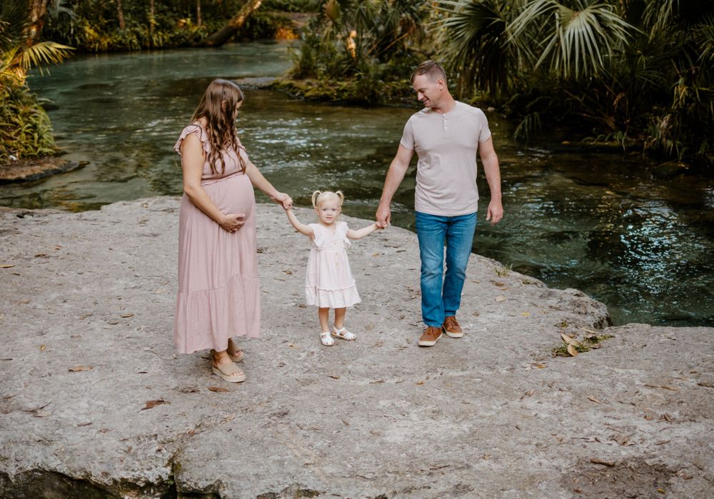 Family walking together on a natural stone path during an outdoor photo session.