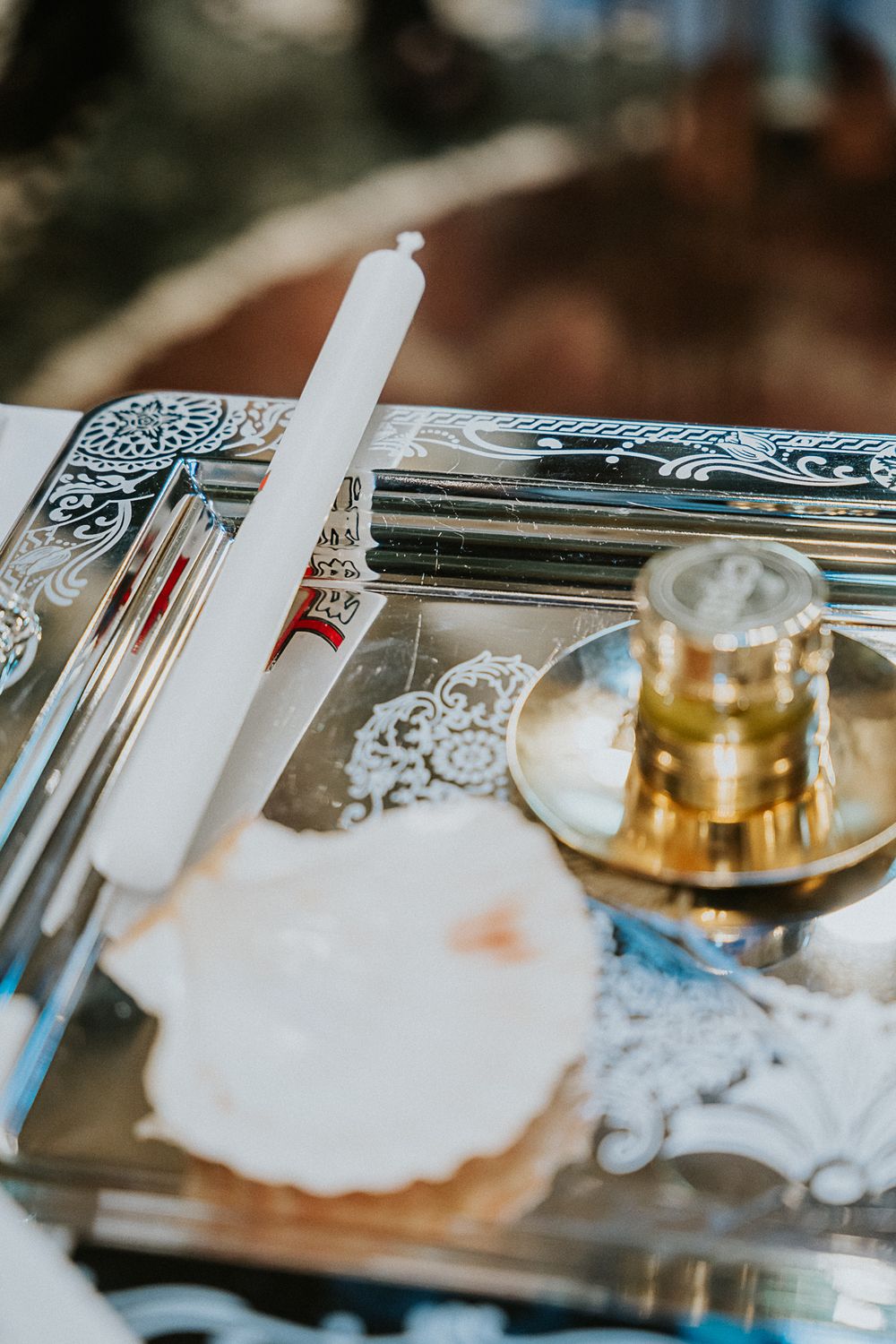 White candle and vinyl records with decorative lace details on a table with a gold candleholder.