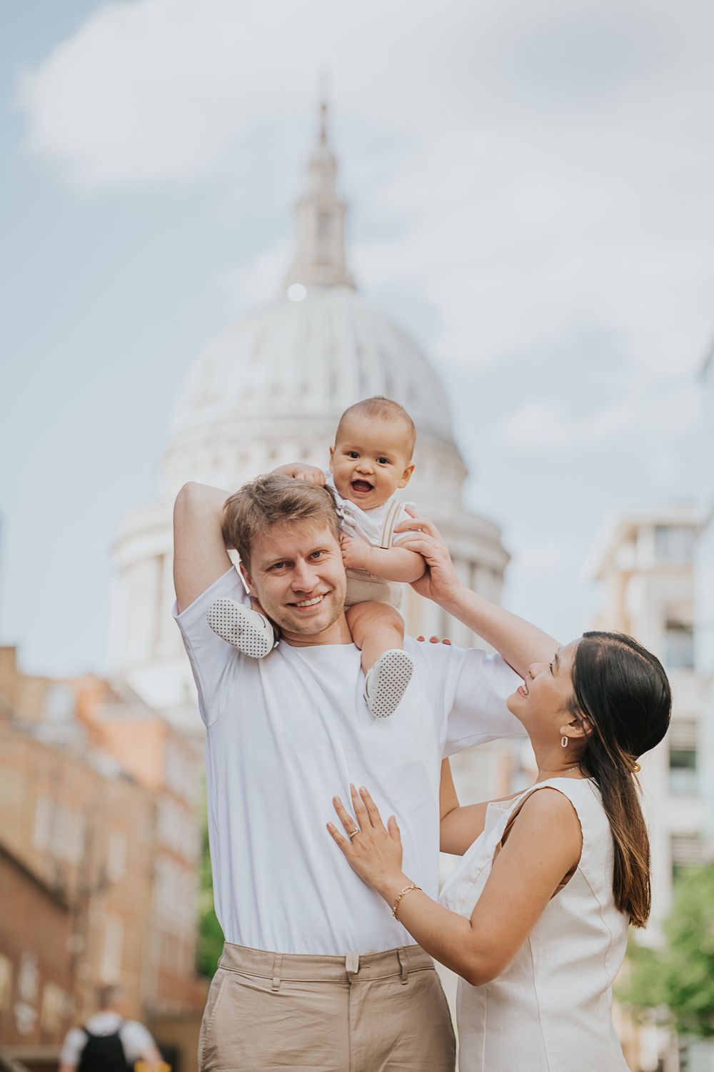A happy family shares a joyful moment together in front of St. Paul's Cathedral in London.