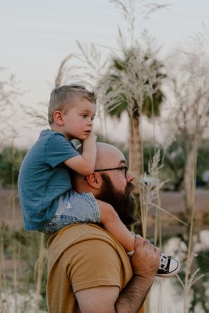 A heartwarming moment captured between parent and child against palm trees at sunset.