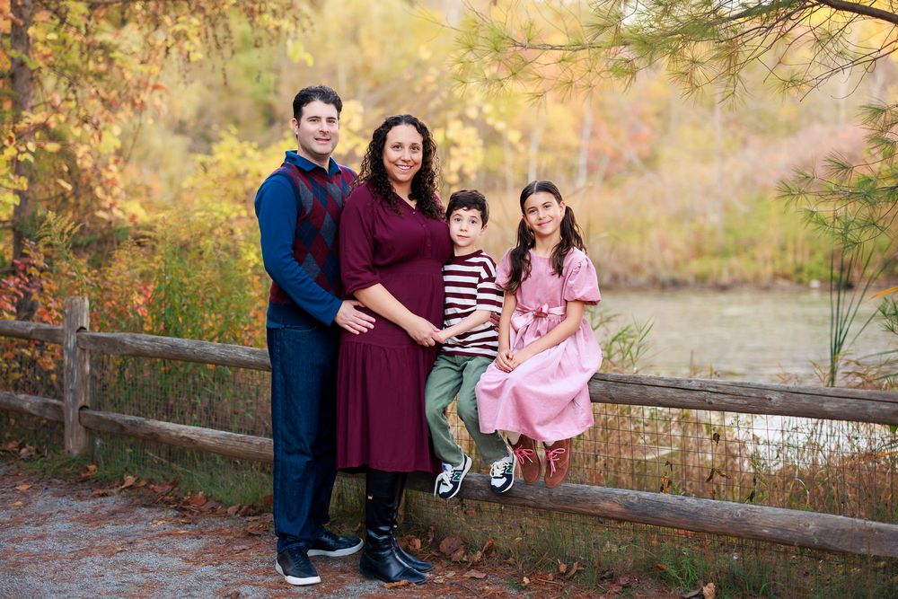 Family of four posing together during an outdoor fall family photography session in Toronto