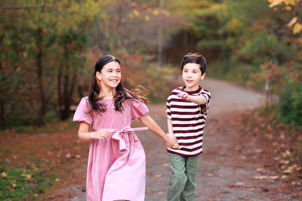 Brother and sister walking together during a fall family photo session in Toronto