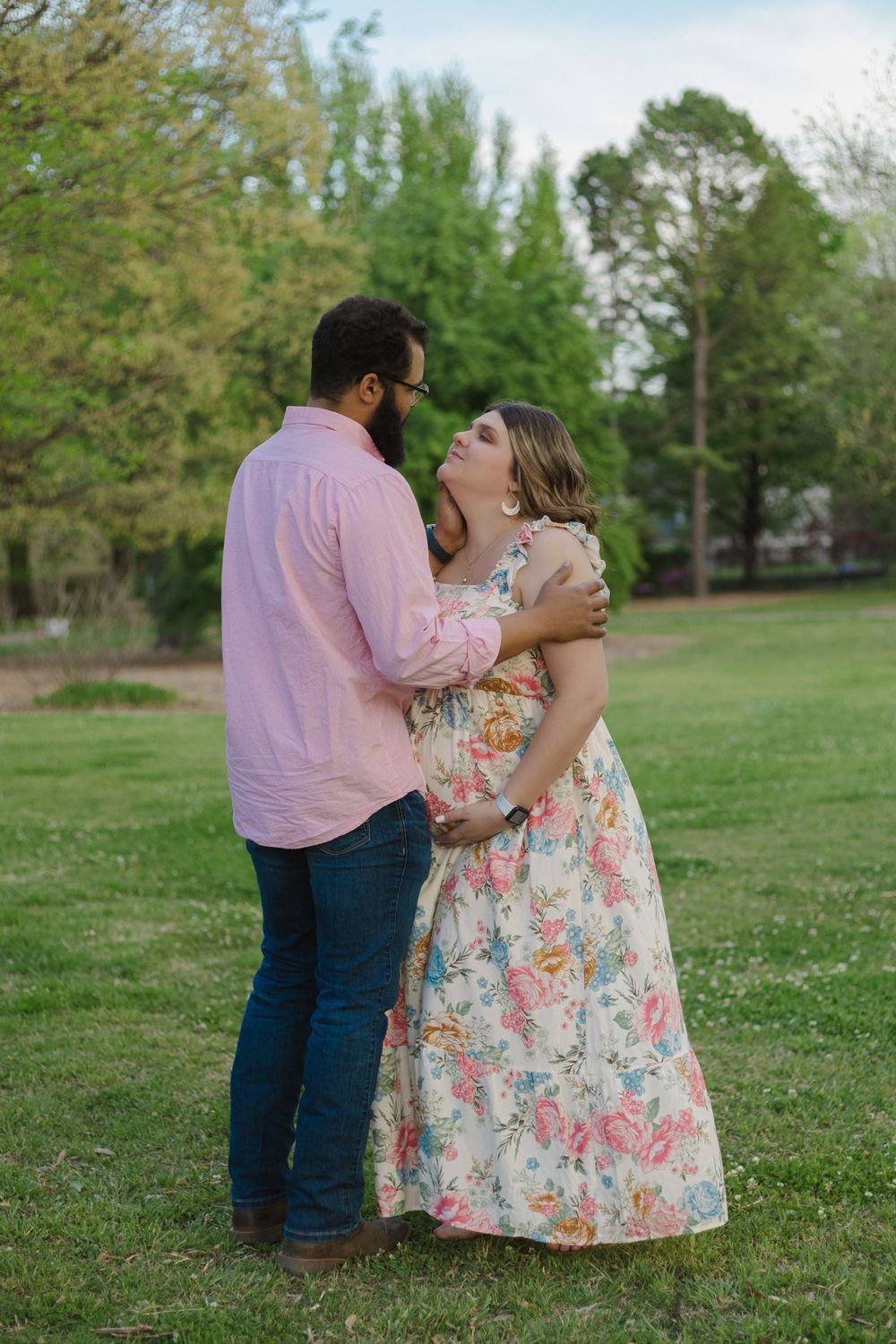 A tender moment shared between a couple on grassy grounds during a spring photoshoot.