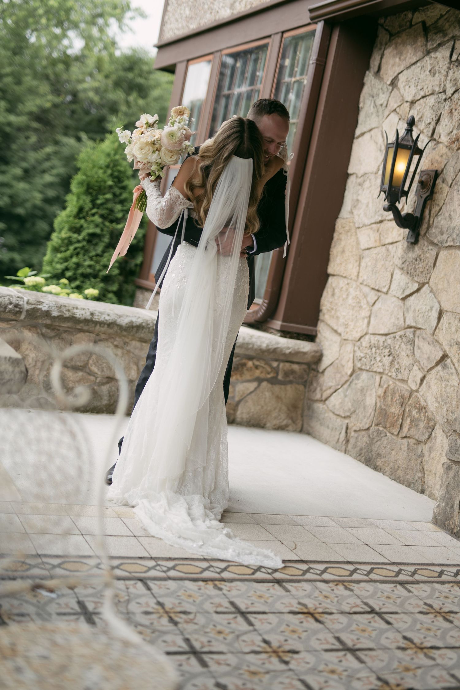 Stone patio with decorative tile pattern and stone wall exterior of elegant venue.