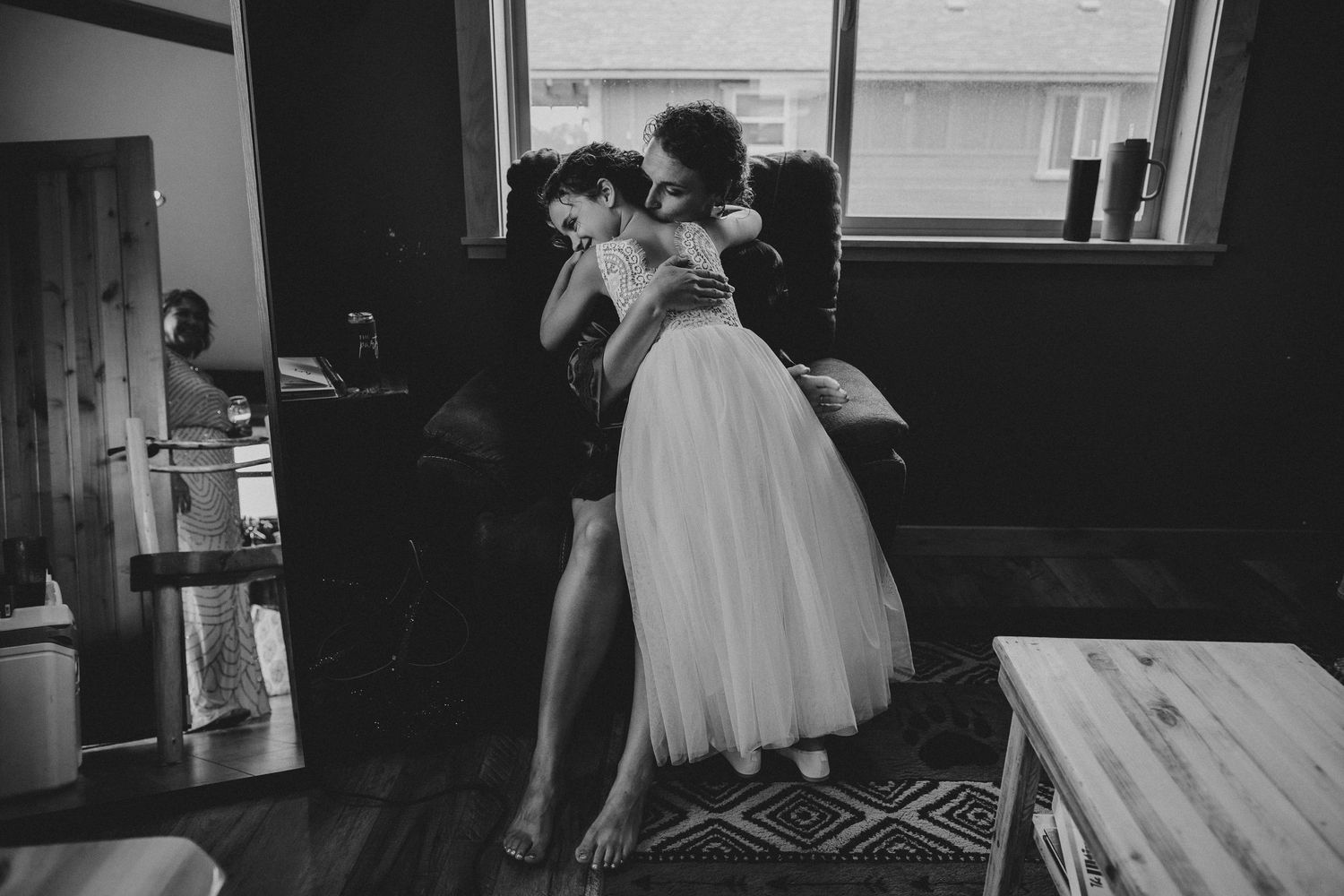 Hugs between a mom and her daughter, the flower girl, while getting ready for a wedding.