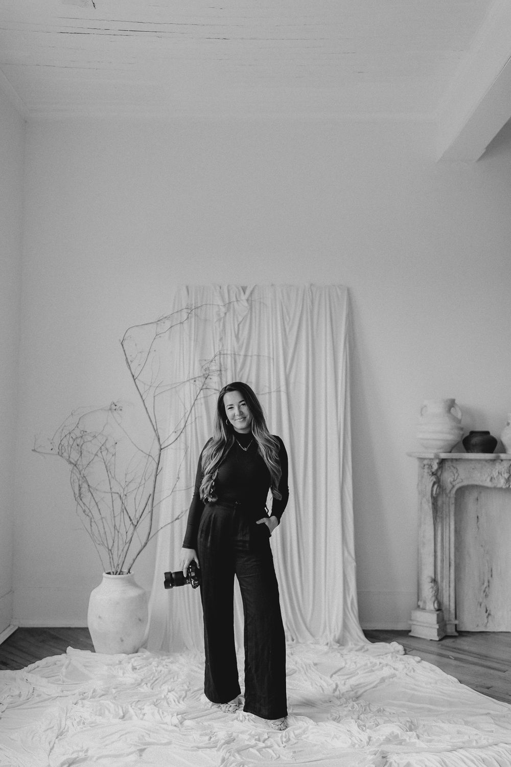 Minimalist black and white studio portraits with white curtain backdrop and simple decor.