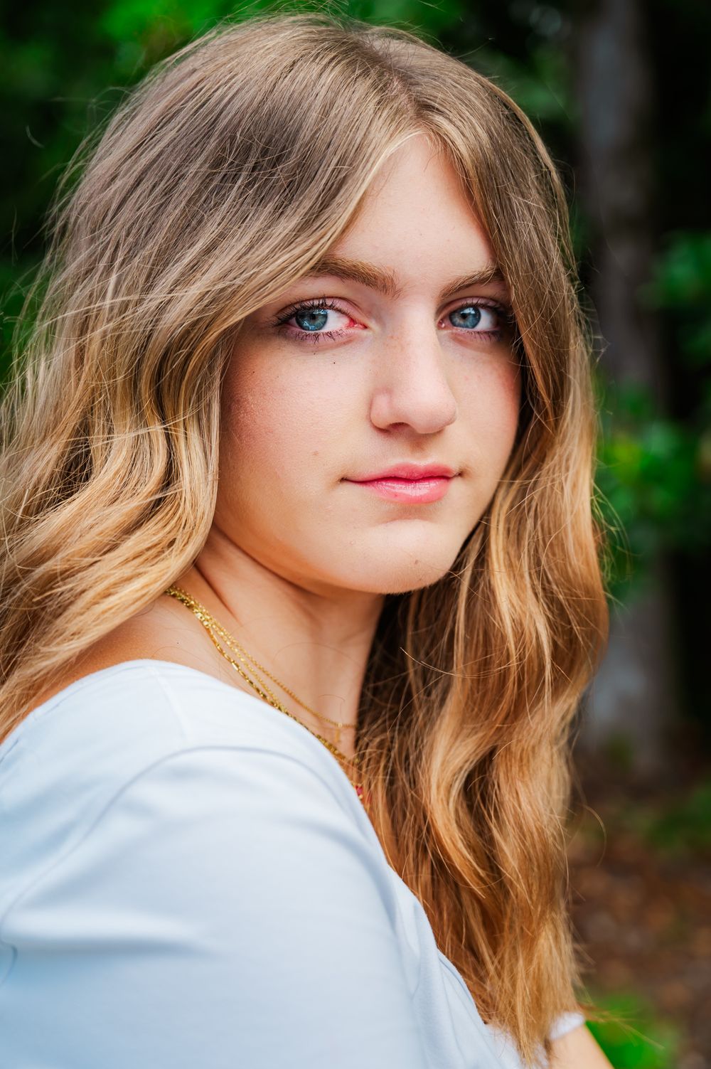Beautiful outdoor portrait with natural lighting and soft focus background in wooded setting.