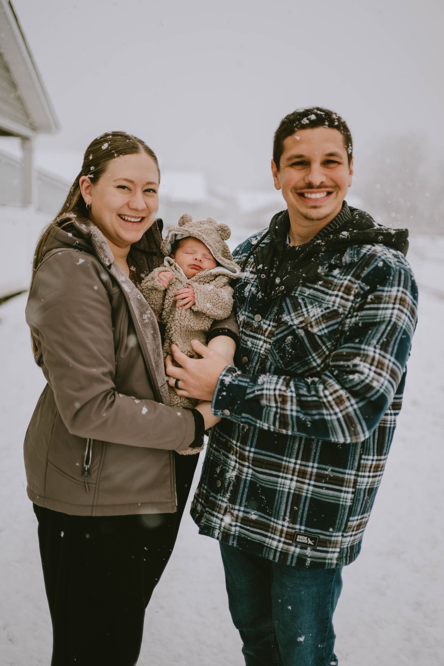 Winter outdoor family photos showing joyful moments with baby in the snow.