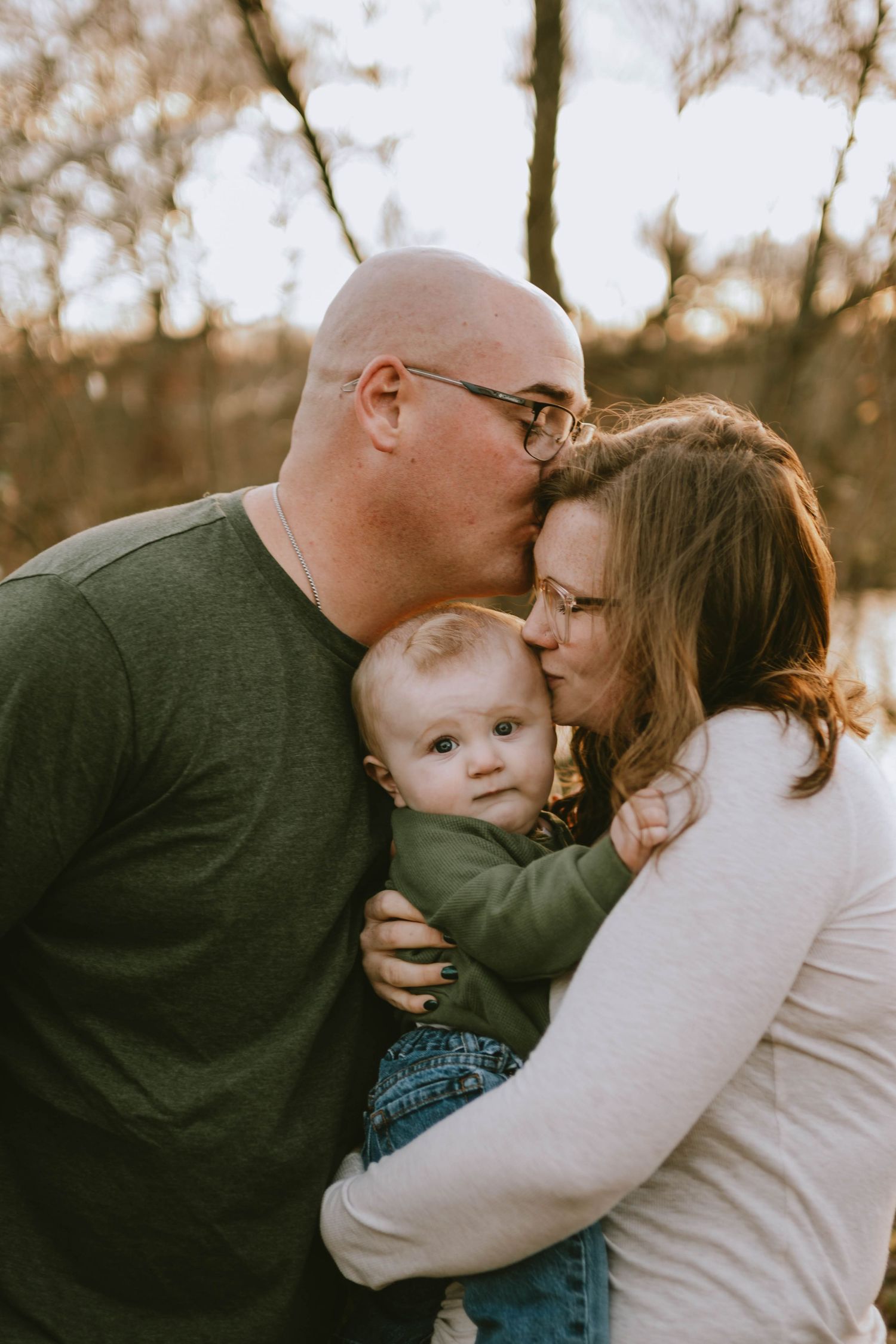 Sunset family photoshoot showing tender embraces in natural outdoor setting.