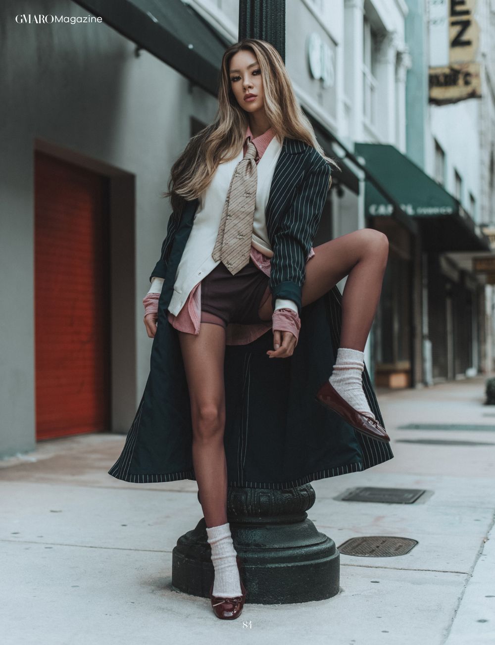 Street fashion photo of pinstripe coat and shorts ensemble with knee socks and platform shoes.