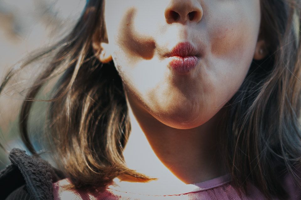 niña rubia tirando besos. reportaje fotográfico familiar en Madrid