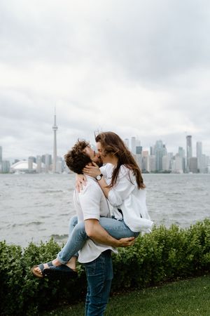 A couple embraces in front of the Toronto skyline and CN Tower -Muskoka wedding photographer-Alexis Anne Photography