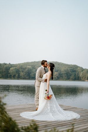 Couple embraces by a lakeside on the dock at Trillium resort-Cottage Country flowers--Alexis Anne Photography