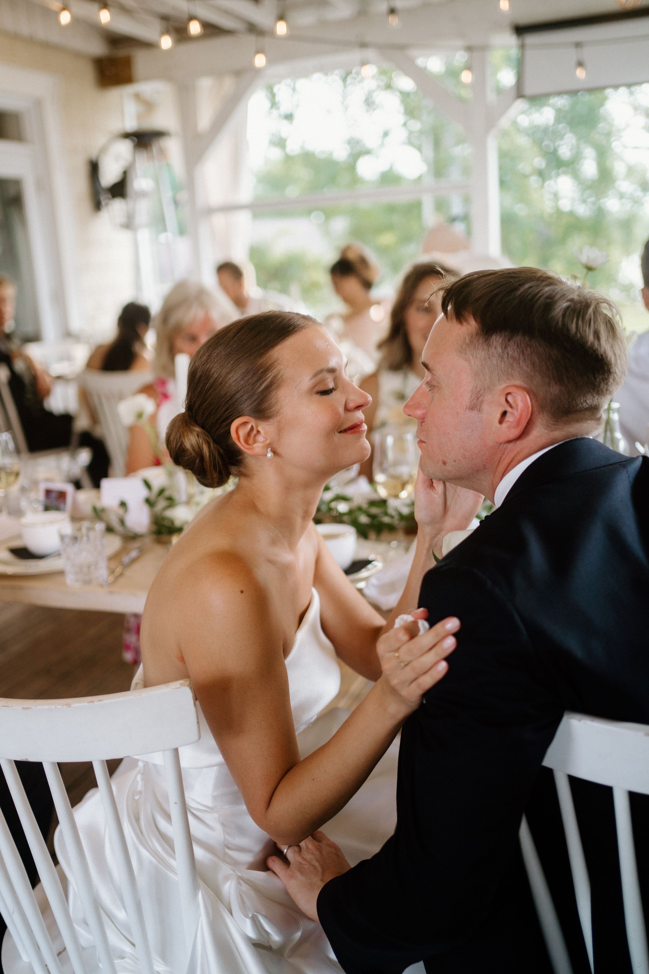 Intimate kiss at their wedding reception with guests in the background-Northridge Inn-Alexis Anne Photography-Muskoka wedding photography