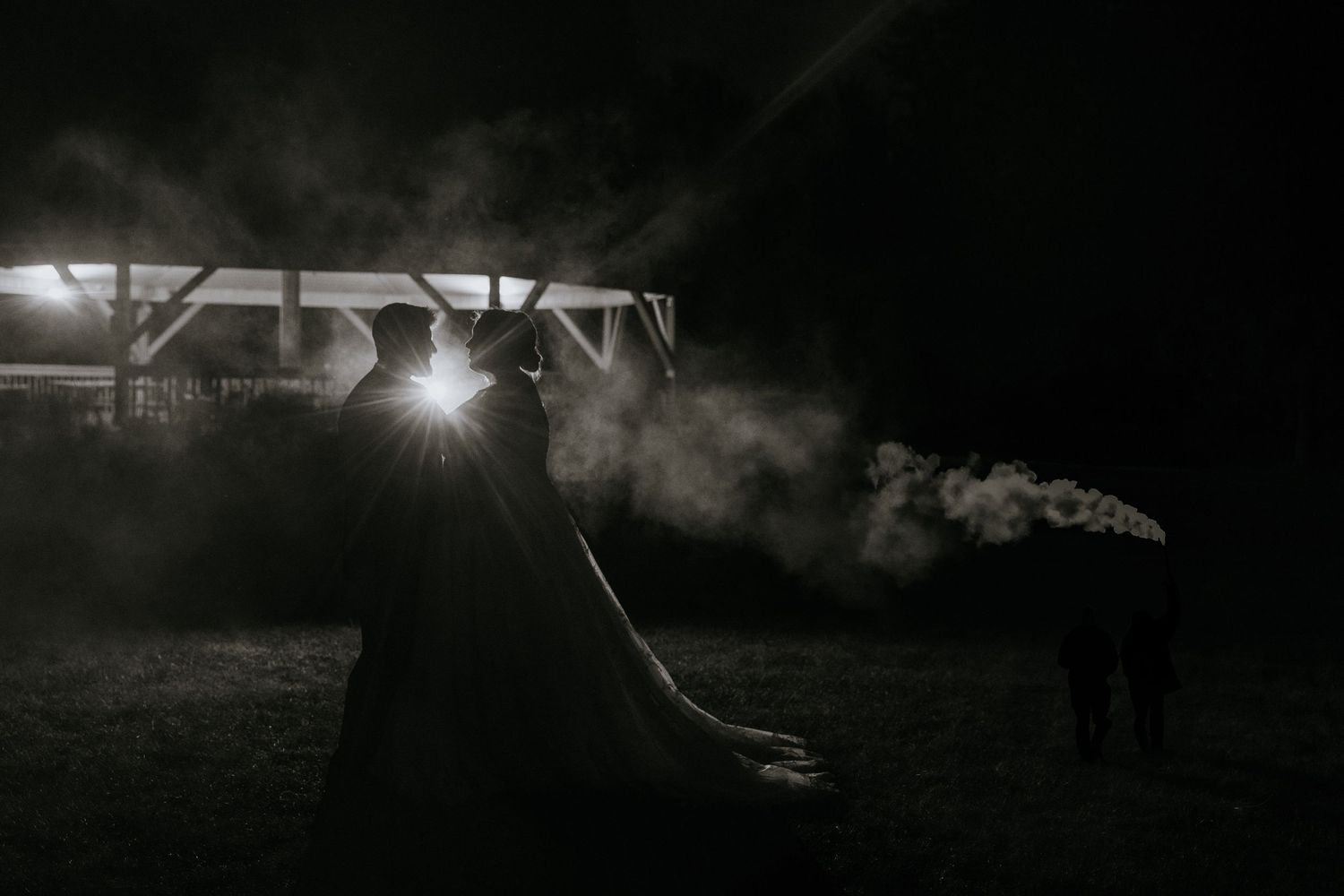 Dark and moody black and white photograph showing a silhouetted figure standing in front of a bright light source.