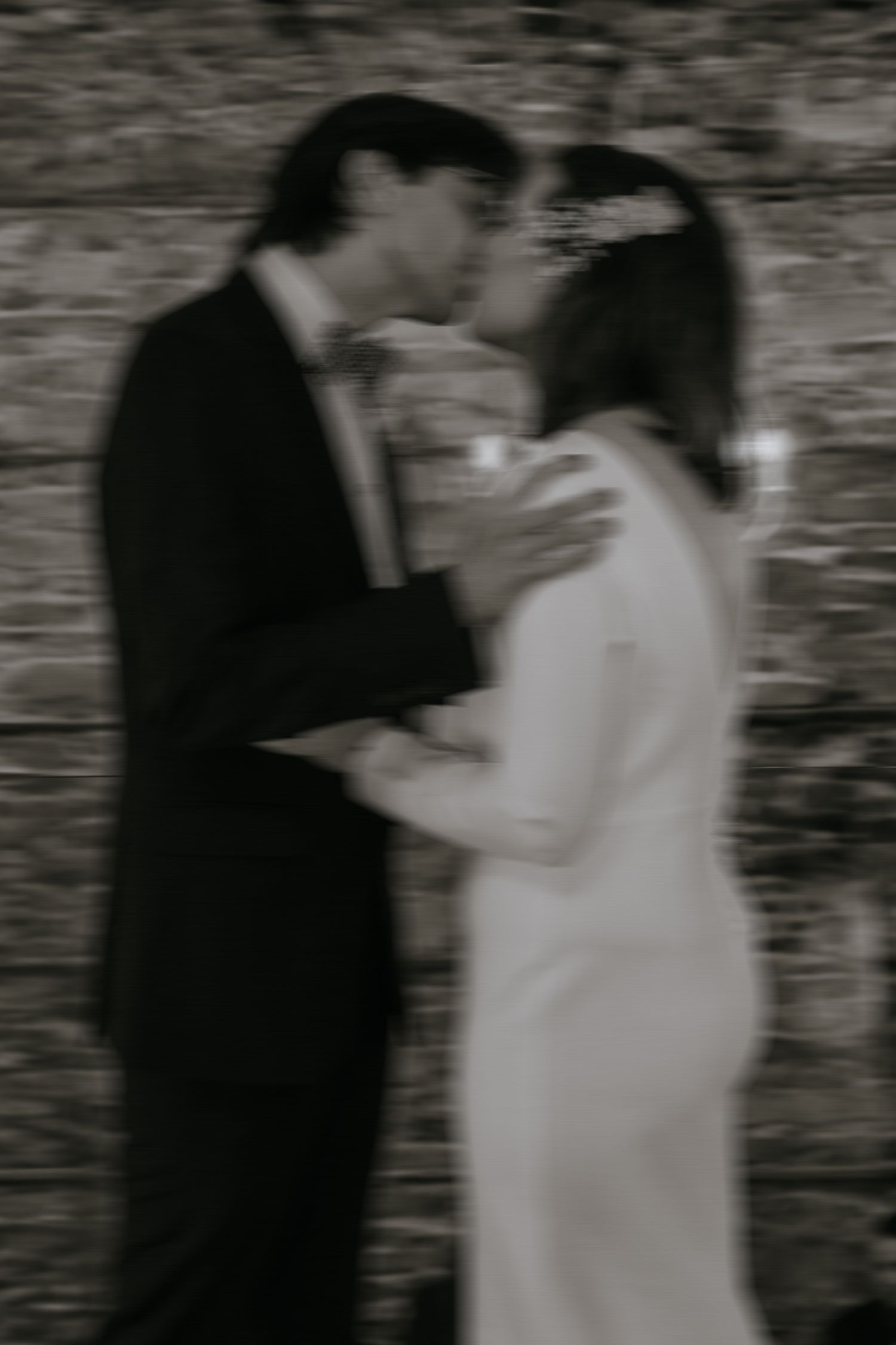 A romantic black and white photo sequence shows a couple in formal attire sharing intimate moments against a textured wall.